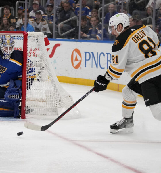 Boston Bruins' Dmitry Orlov (81) passes as St. Louis Blues goaltender Jordan Binnington defends during the first period of an NHL hockey game Sunday, April 2, 2023, in St. Louis.
