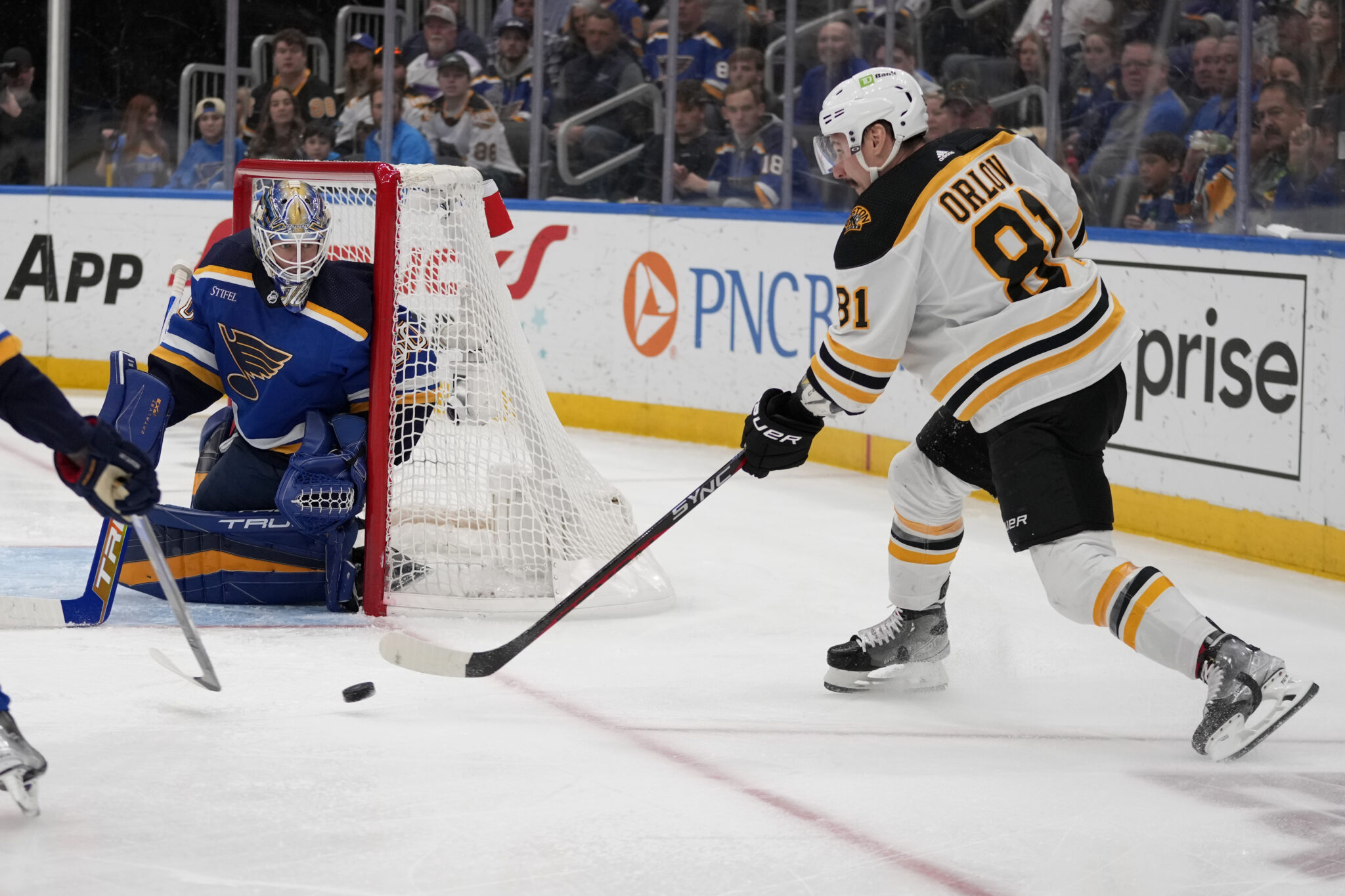 Boston Bruins' Dmitry Orlov (81) passes as St. Louis Blues goaltender Jordan Binnington defends during the first period of an NHL hockey game Sunday, April 2, 2023, in St. Louis.