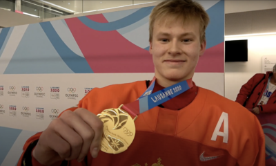 Matvei Michkov holds his gold medal.